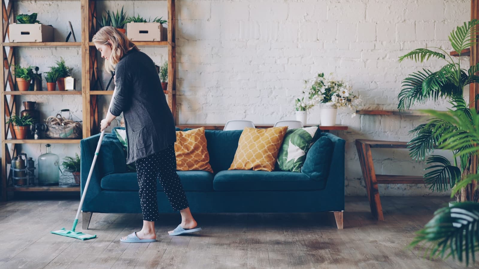Woman cleaning floors in a bright, modern living room